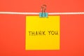 Yellow paper note on clothesline with text Ã¢â¬ÅThank YouÃ¢â¬Â Royalty Free Stock Photo